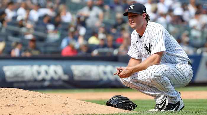 Yankees pitcher Gerrit Cole crouches beside the mound